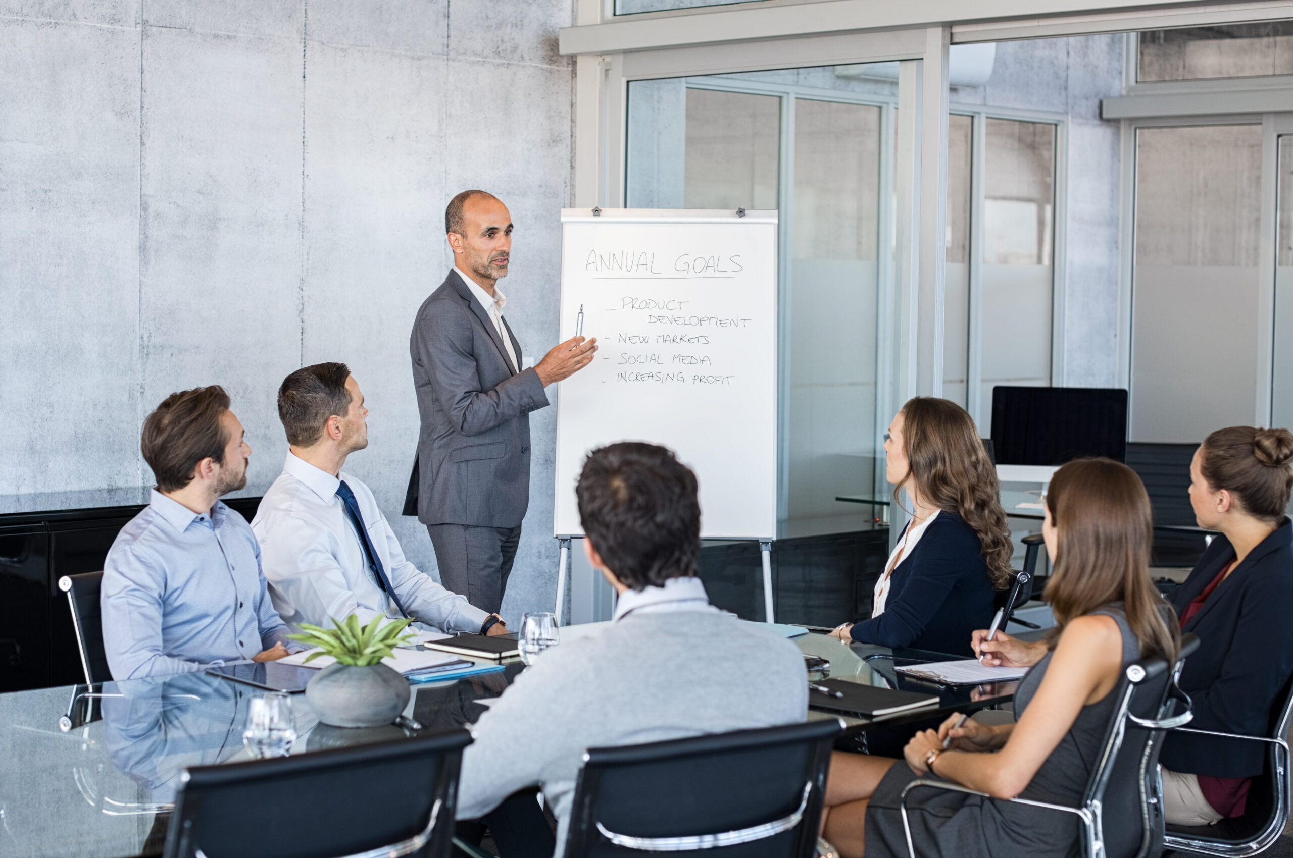 Confident,Mature,Businessman,Giving,A,Presentation,To,His,Team,In